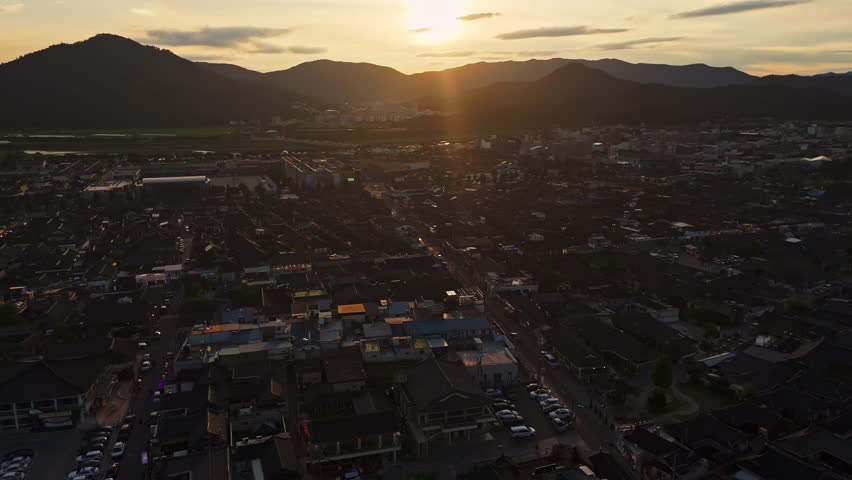 Aerial view backwards over the cityscape of Gyeongju, golden hour in South Korea