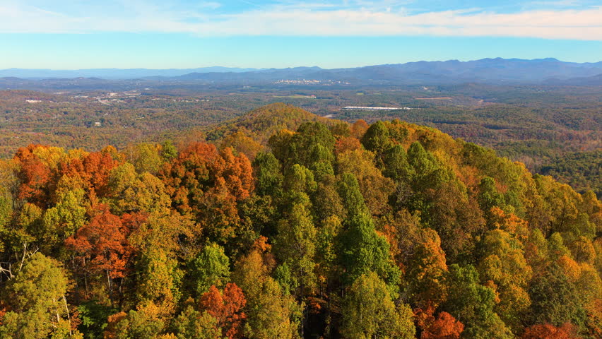Scenic mountain landscape in North Carolina featuring colorful Appalachian forests during peak autumn. Vibrant foliage covers every hillside.