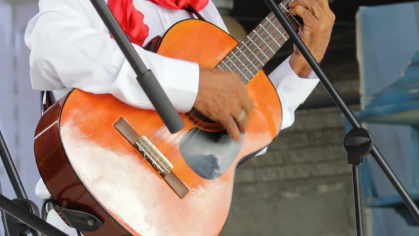 An unrecognizable person plays an acoustic guitar on a stage during a folk music show in Neiva, Huila, Colombia. Concept of Colombian culture