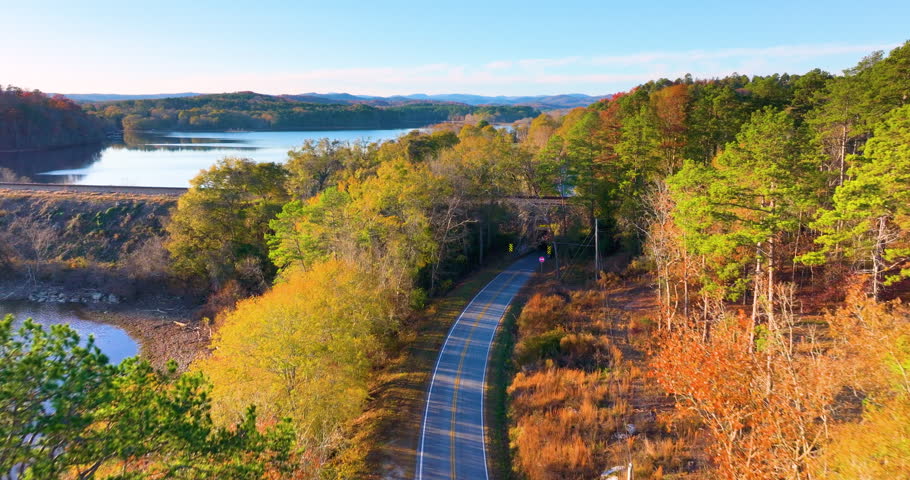 Vibrant autumn landscape in South Carolina mountains. Fall colors stretch across hillsides along quiet mountain road.