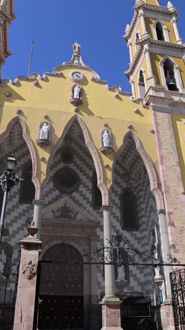 View of the historic Catedral Basilica de la Inmaculada Concepcion with its yellow facade and intricate stone arches in Mazatlan, Sinaloa, Mexico.