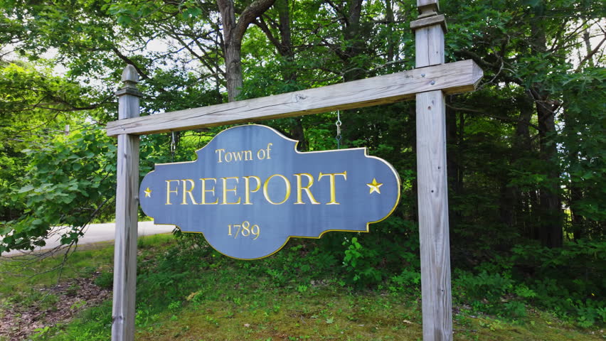 Freeport Maine 1789 signboard framed by dense shadowy forest
