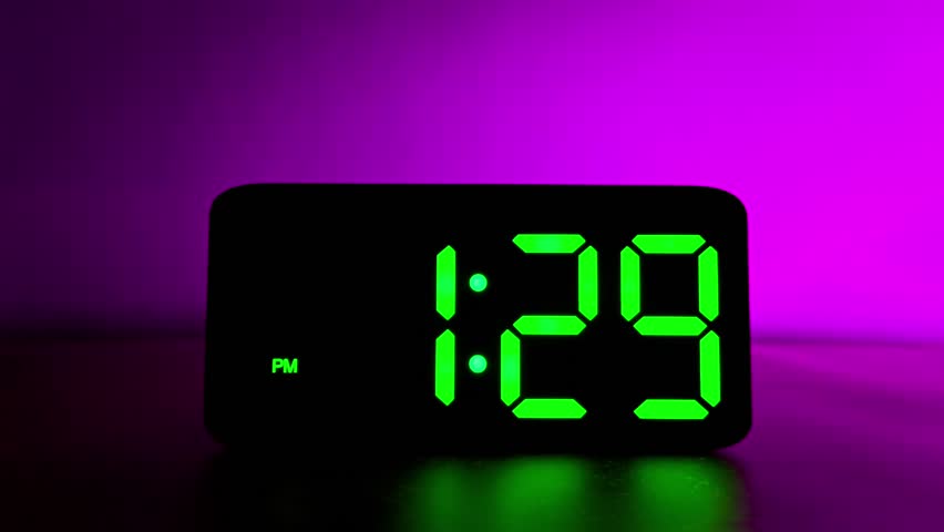 Glowing green digital clock changing from 1:29 to 1:30 PM on neon purple background