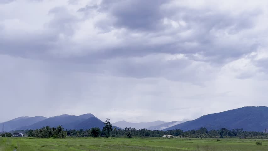 Dark Storm Clouds Over Mountain Landscape With Rainfall and Green Field Nature Scenery