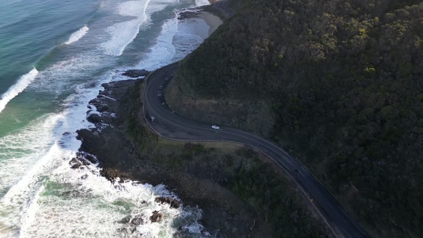 Drone travel view of Great Ocean Road Australia featuring dramatic cliffs mountain landscapes and coastal highway beside the Southern Ocean