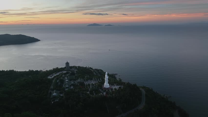 Aerial view of Linh Ung Pagoda and giant Bodhisattva statue on Son Tra Peninsula at sunset, Da Nang, Vietnam.