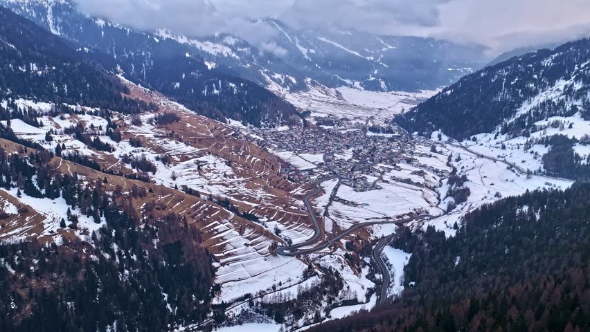 Aerial moving time lapse of Nauders township and snow-covered mountains in Austria.