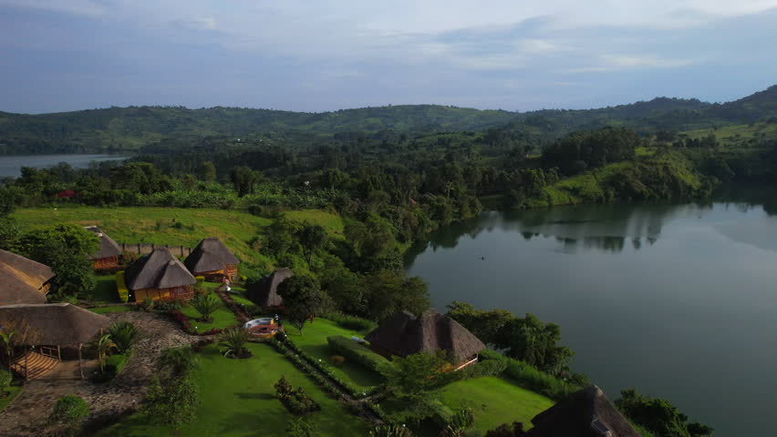 Aerial dolly out view revealing African rural eco lodge by lakes