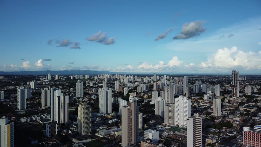 An aerial view of Cuiaba, Brazil, featuring modern cityscape amid lush green vegetation and forest