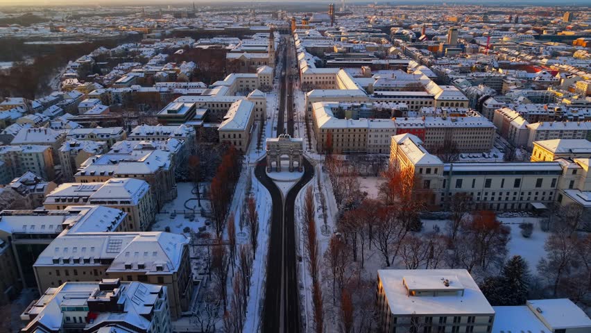 Snow covered Siegestor and Ludwigstrasse seen from above on a crisp winter morning, capturing Munich historic architecture and serene cold season atmosphere