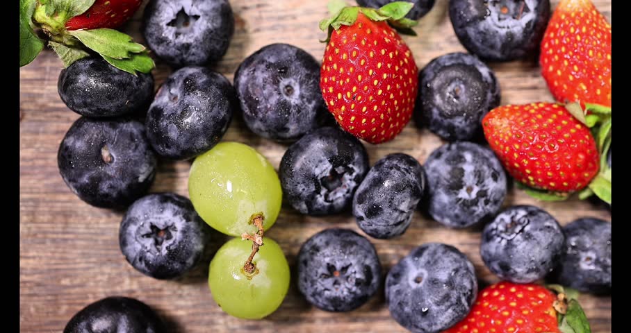 Fresh ripe Blueberry strawberry grape macro closeup on wood dark white background slide move organize 