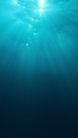 Group of bottlenose dolphins emerges from darkness morning ocean, their silhouettes revealed by bright sunshine. Dolphins swim beneath dancing sun rays in blue water at sunrise, backlit by sunlight.