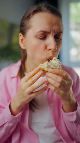 Woman with eating disorder eating a donut with a sense of guilt
