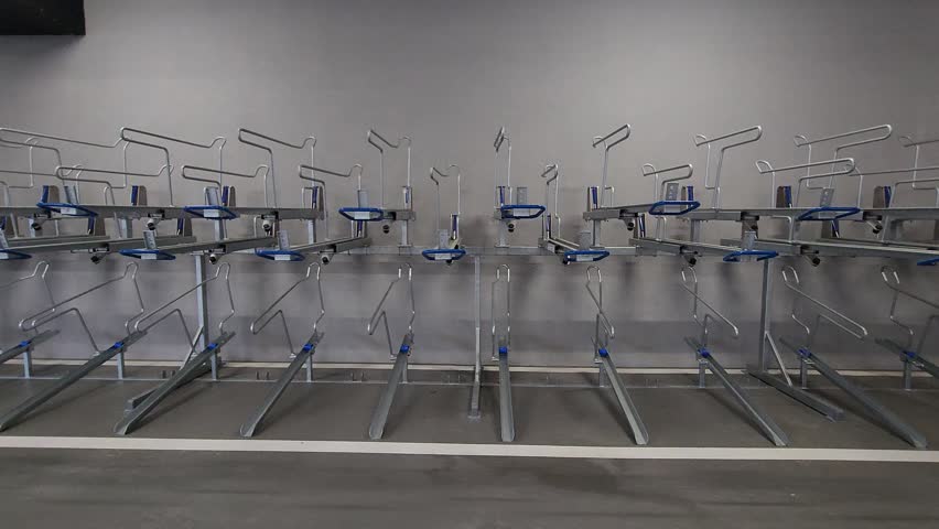 Empty indoors bicycle parking with double bike racks in panning shot