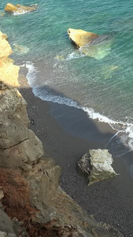 Vertical video of the rocky shore of Crete Island with turquoise clear transparent Mediterranean sea water. Sandy beach near Gerapotamos. Crete, Greece.