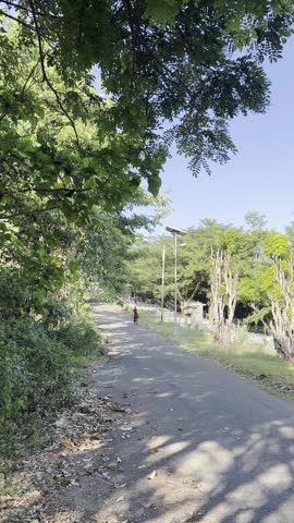 Man Cycling on a Rural Road