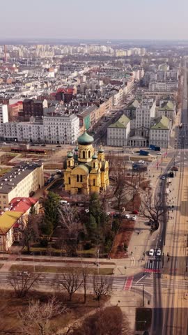 Vertical screen Aerial View Yellow Orthodox Church Warszaw, Drone Captures Green Domes And Ornate Facades Amid Residential Blocks, Long Avenue Receding Into Horizon, Winter Light, Calm Urban