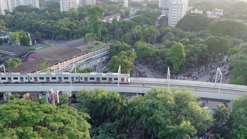 Drone view of a metro train on an elevated railway near a mosque in Dhaka
