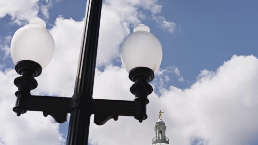 Cinematic tilt down from a decorative light post revealing the Rhode Island State House and its marble dome on a sunny summer day in Providence.