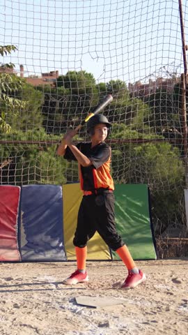 Slow motion footage of a kid swinging a baseball bat and running to first base during training. Youth league game on a sunny summer day