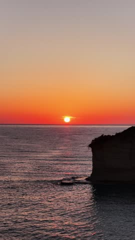 Stunning golden sunset over the sea and unique rock formations at Apotripiti Beach in Peroulades, Corfu, Greece.