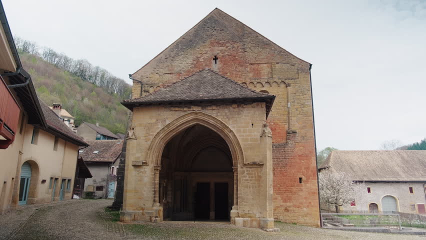 Gimbal shot of Romainmotier Priory, former Cluniac priory, during the day in Romainmotier, canton of Vaud, Switzerland