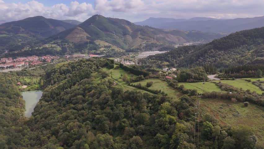An aerial footage of the city of Bilbao in Basque Country, Spain during daytime, with Pagasarri mountains in the background