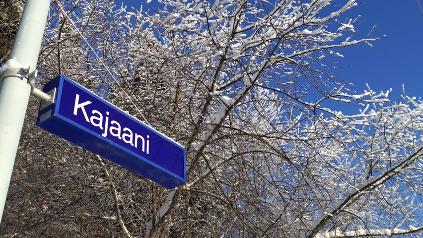 Close-up of Kajaani station sign in snowy winter conditions at a Finnish railway station platform - Finland