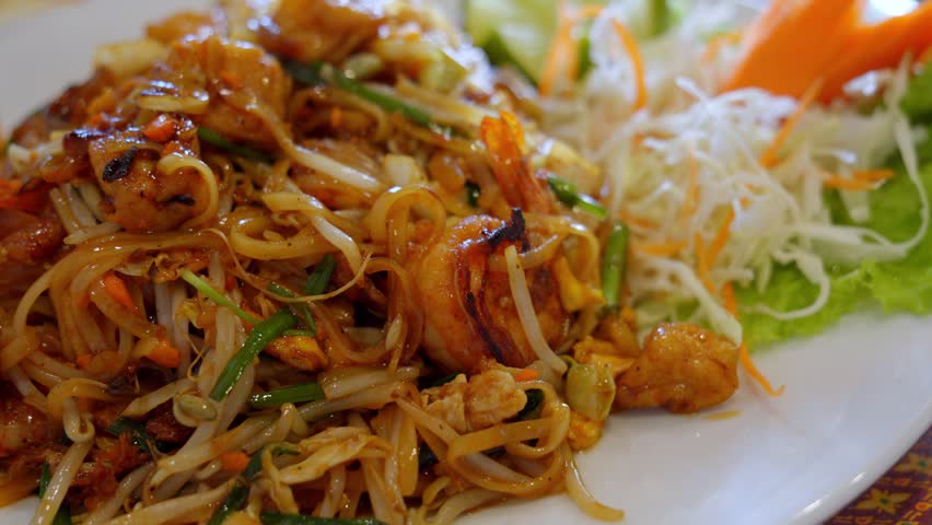 Traditional Pad Thai noodles with shrimp and fresh vegetable garnish