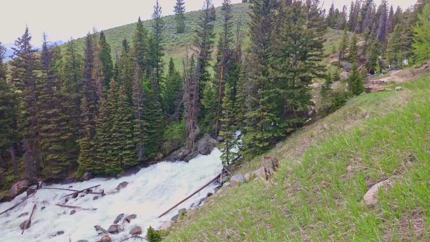 Scenic waterfall on Lake Creek flowing through the mountains beside Beartooth Highway in Wyoming
