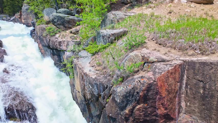 Scenic waterfall on Lake Creek flowing through the mountains beside Beartooth Highway in Wyoming