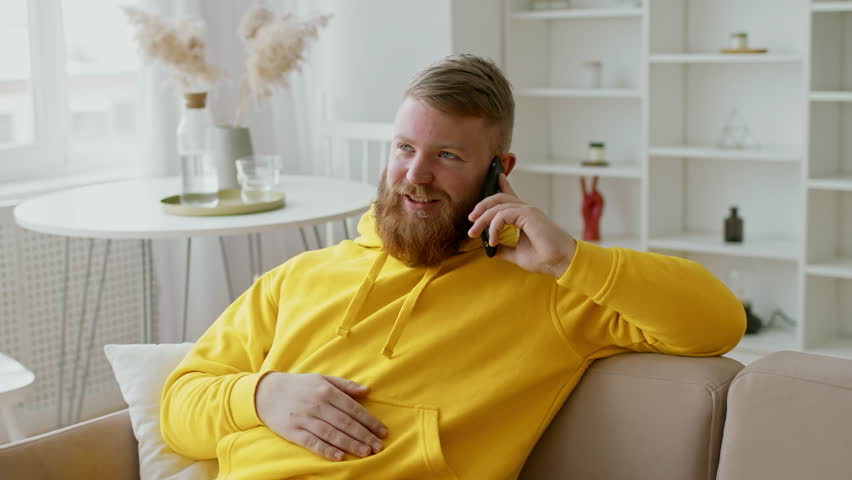 Man With Beard Talking On Phone At Home, Relaxed Lifestyle Concept
