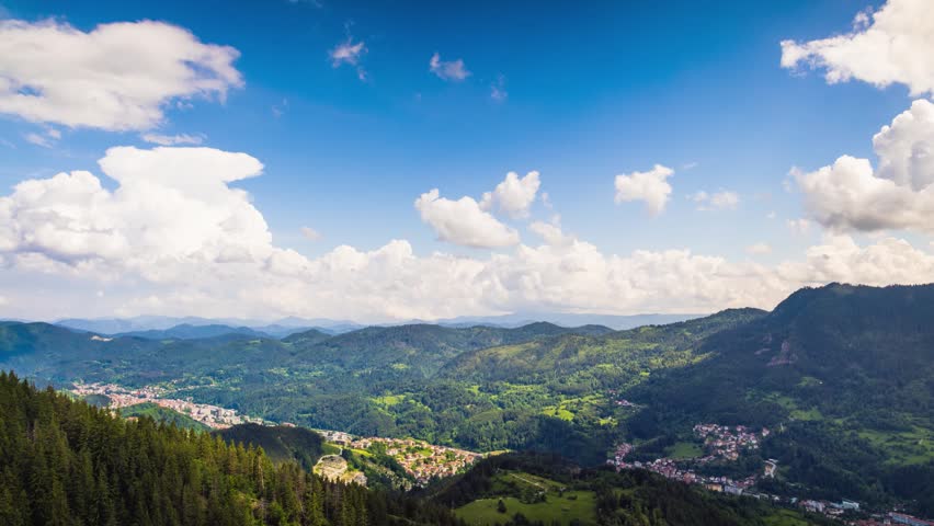 View from rock to town of Smolyan with meadows for cattle walking and houses between mountain range of Rhodope Mountains