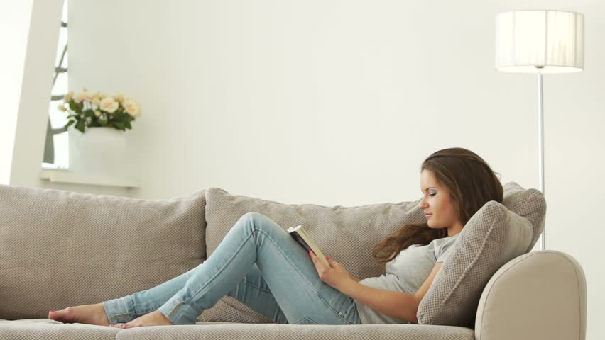 Young woman reading book and smiling
