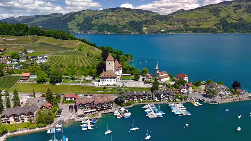 Aerial view of the medieval Spiez Castle and marina on the shore of Lake Thun in Switzerland