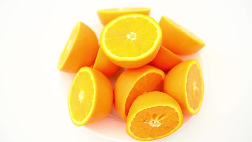 A top-down overview of juicy, freshly sliced orange halves rotating smoothly against a pure white background. The ultimate visual for summer energy, citrus flavor, and vitamins.
