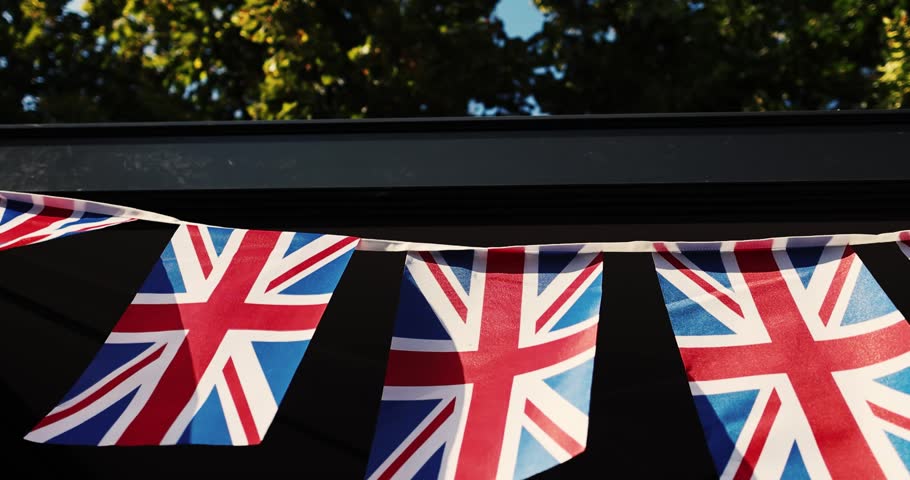 Details with the United Kingdom flags waving in the wind during a UK national celebration.
