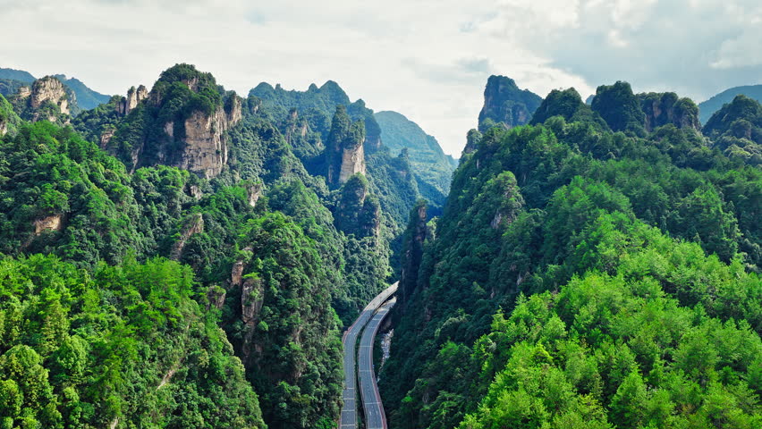 Aerial view of highway winding through green mountain peaks  in Wulingyuan, Zhangjiajie, China