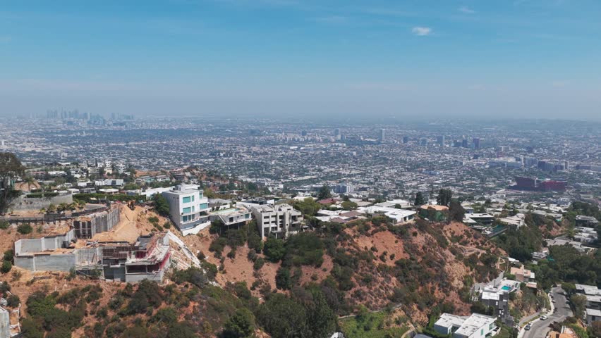 Aerial descending dolly shot of homes perched on the hills above Los Angeles, California. 4K