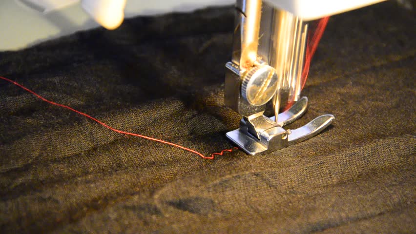 sewing machine and item of black clothing with a contrast red thread. Extreme
