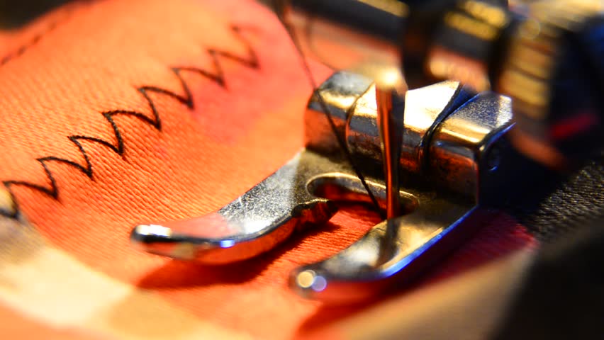 Closeup of sewing machine working part with colorful cloth. Needle stitch zigzag