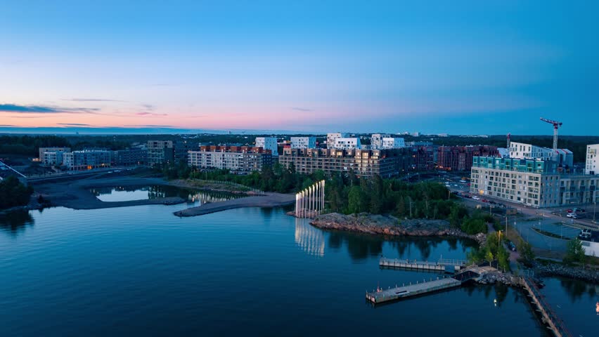 Aerial view of the modern residential area of Kruunuvuorenranta at dusk with calm waters and piers in Helsinki, Uusimaa, Finland.