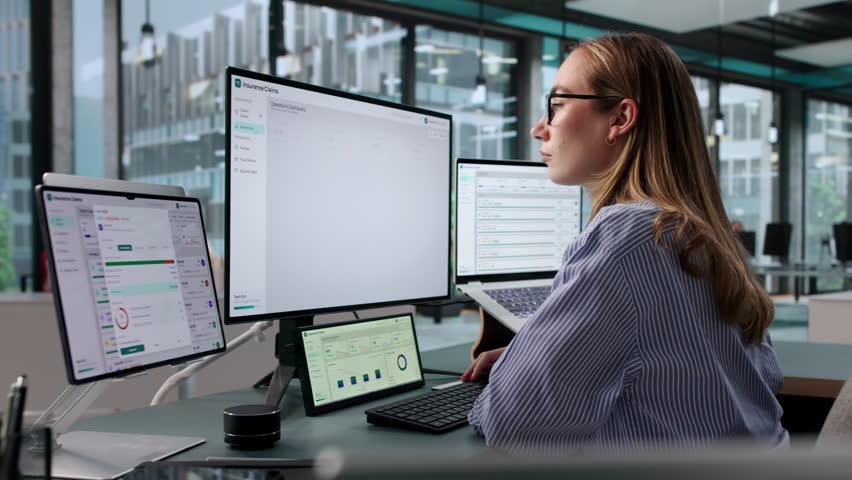 Insurance Adjuster Reviews Claim Status Using Laptop On Modern Workbench.