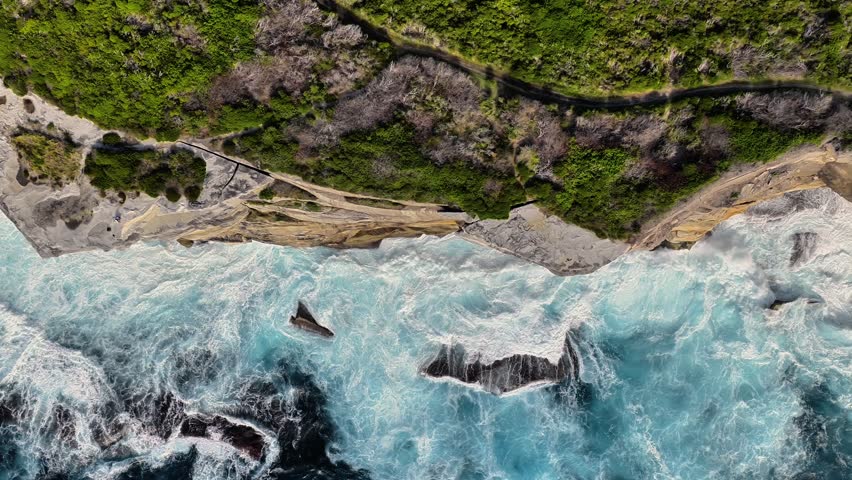 Aerial view of Kurnell cliffs with crashing ocean waves and lush coastal vegetation in Sydney, New South Wales, Australia.