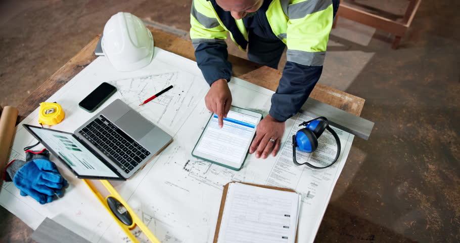 Top view, tablet screen and engineer at construction site for building development, project or chart. Above, tech and black man with architecture blueprint, floor plan and scroll analytics report