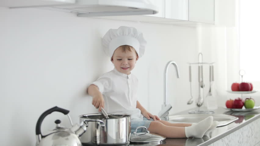 Little chef sitting with ladle and pan
