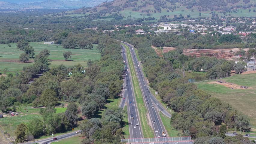 Elevated drone view of the Hume Freeway near Wodonga in regional Victoria, Australia, rolling hills and surrounding bushland landscape on a clear day.