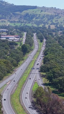 Elevated drone view of the Hume Freeway near Wodonga in regional Victoria, Australia, rolling hills and surrounding bushland landscape on a clear day.