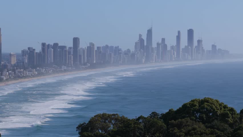 Aerial view tracking to the right along the Surfers Paradise skyline and coastline from Burleigh Heads on the Gold Coast, Queensland, Australia
