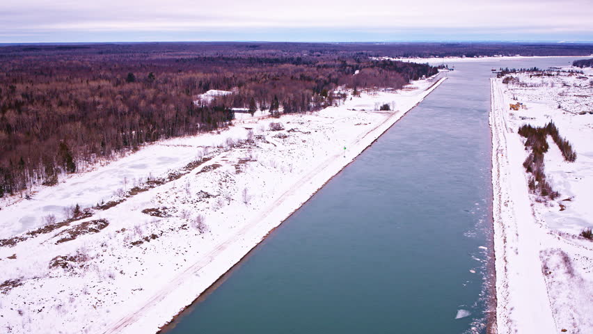Drone shot of winter wilderness leading to a partially frozen bay along Lake Superior.